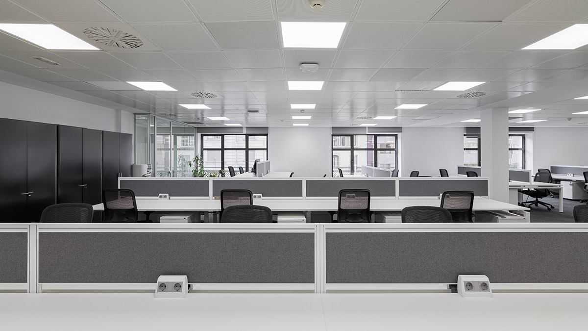 A black and white image of an office with cubicles