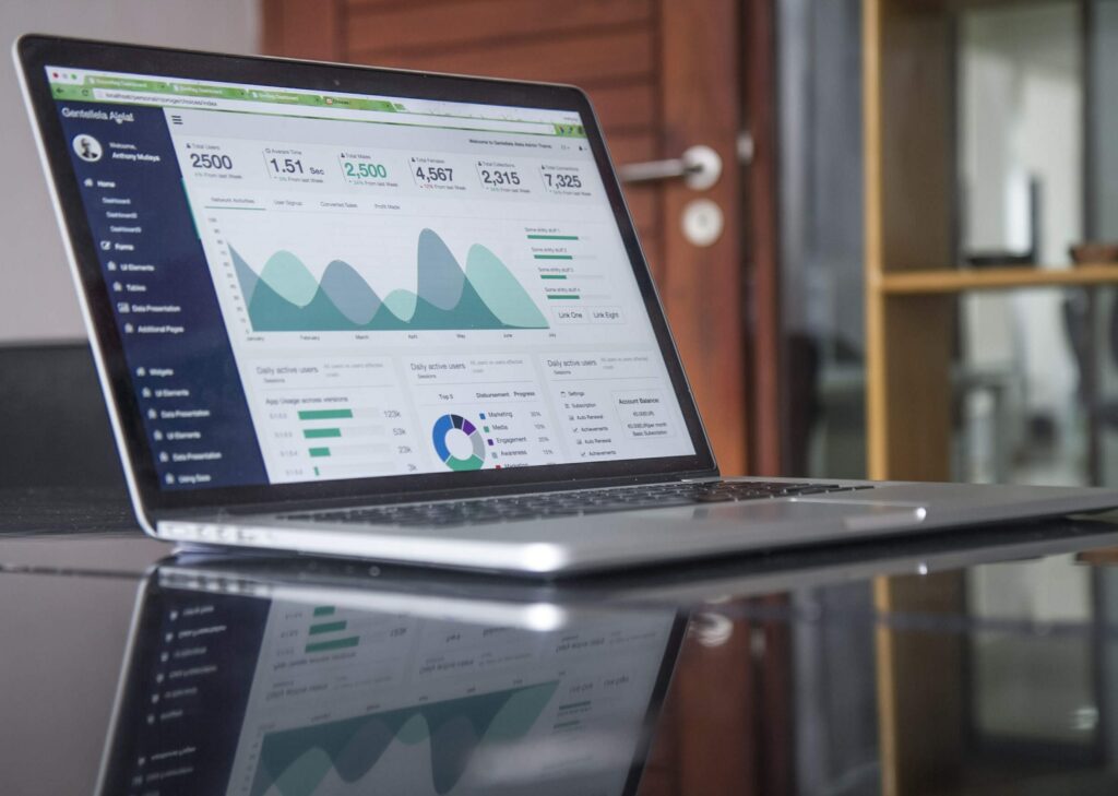 laptop on a desk with graphs on the screen