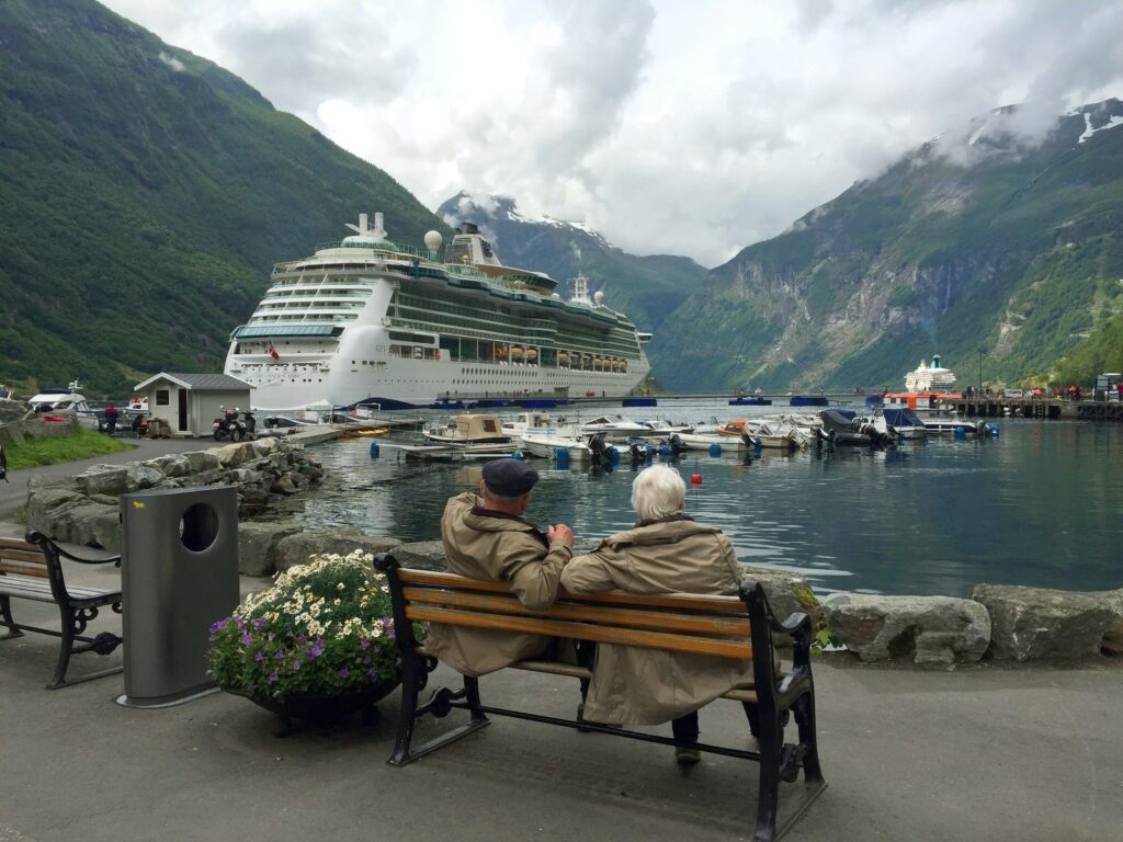 People on a bench looking at a super yacht